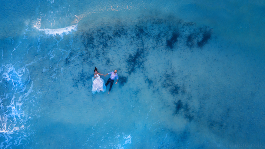 coppia di sposi sdraiata tra le onde, vista dall'alto